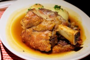 Joelho suíno com polenta e salada de repolho agridoce