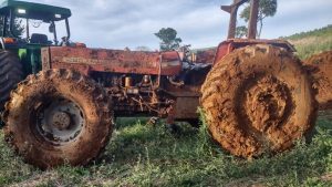 Trator furtado há 7 meses é encontrado enterrado em açude