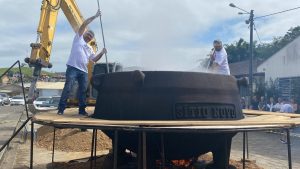 Com “mãozinha” de retroescavadeira festa terá 2.500 litros de caldo de tilápia em super panela